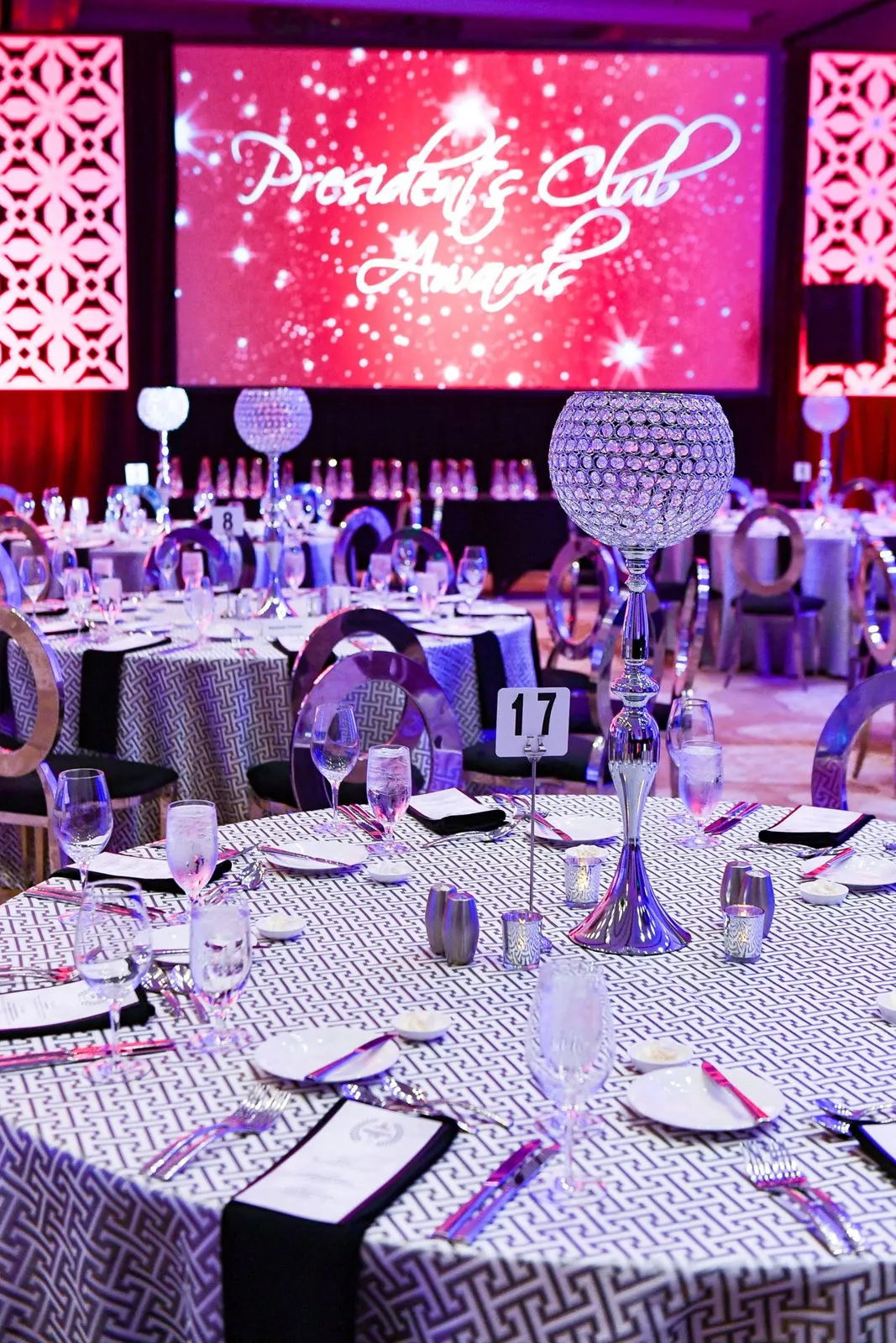 Gala dinner tables in front of a stage screen