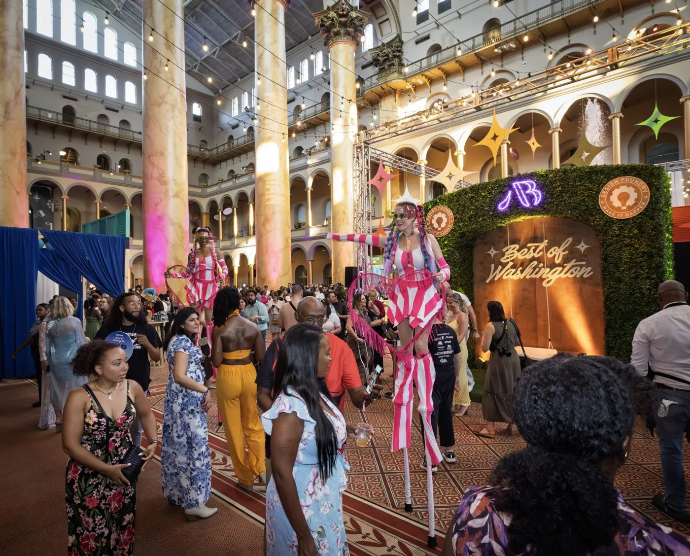 Guests gathering in a grand museum atrium decorated for a large evening event
