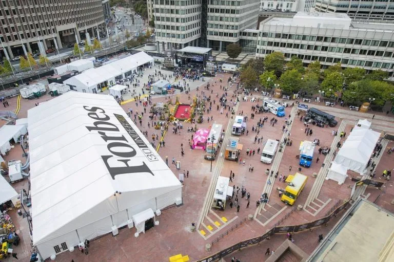 Aerial view of a large branded tent and exhibits on a city plaza