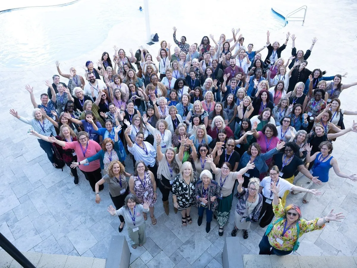 Conference attendees posing together in a group photo taken from above