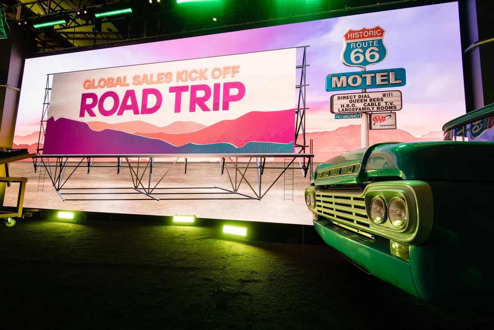 Road Trip stage with a motel sign and vintage truck at a sales kickoff at Fairmont Austin