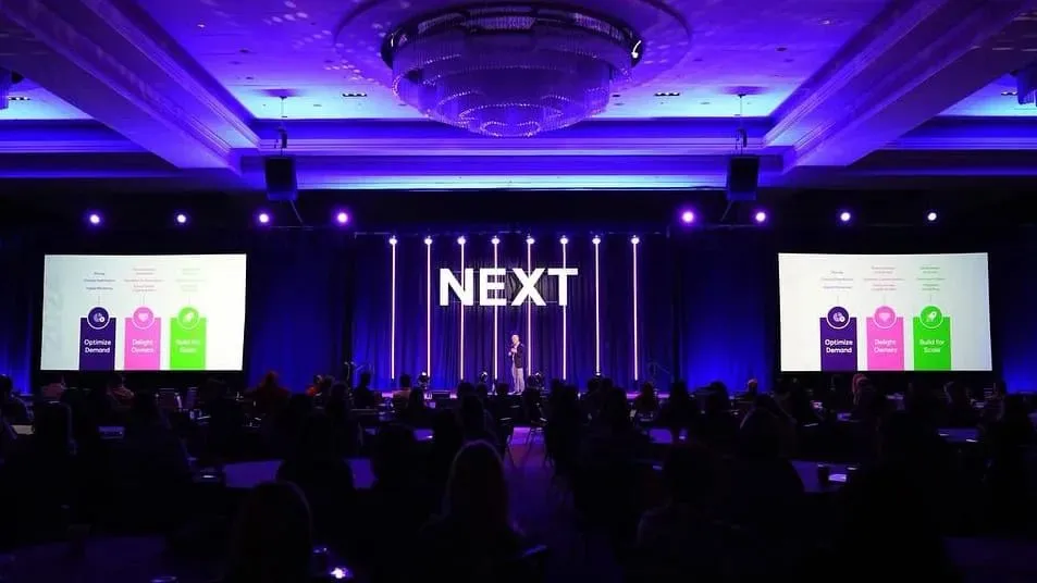 Ballroom conference with a stage screen and colored lighting