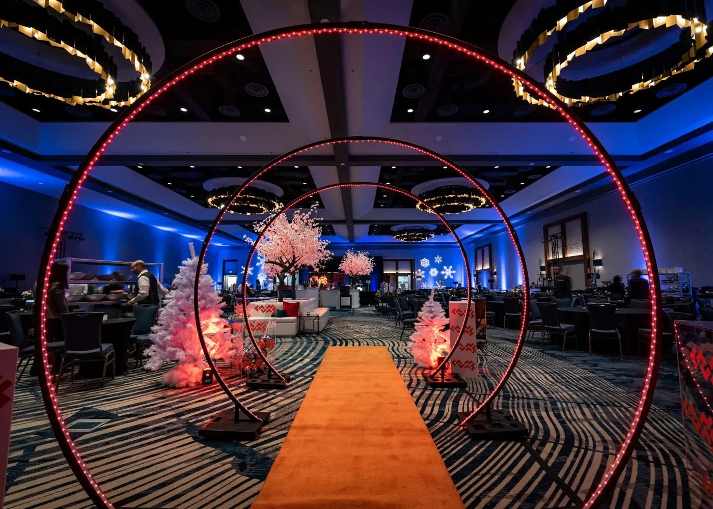 Ballroom with illuminated ring installations and a runway-style aisle