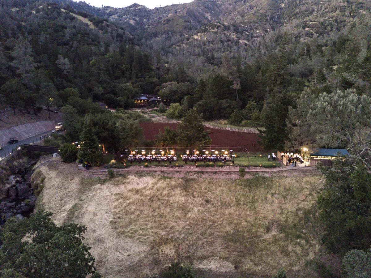 Aerial view of an outdoor dinner set in a wine country valley