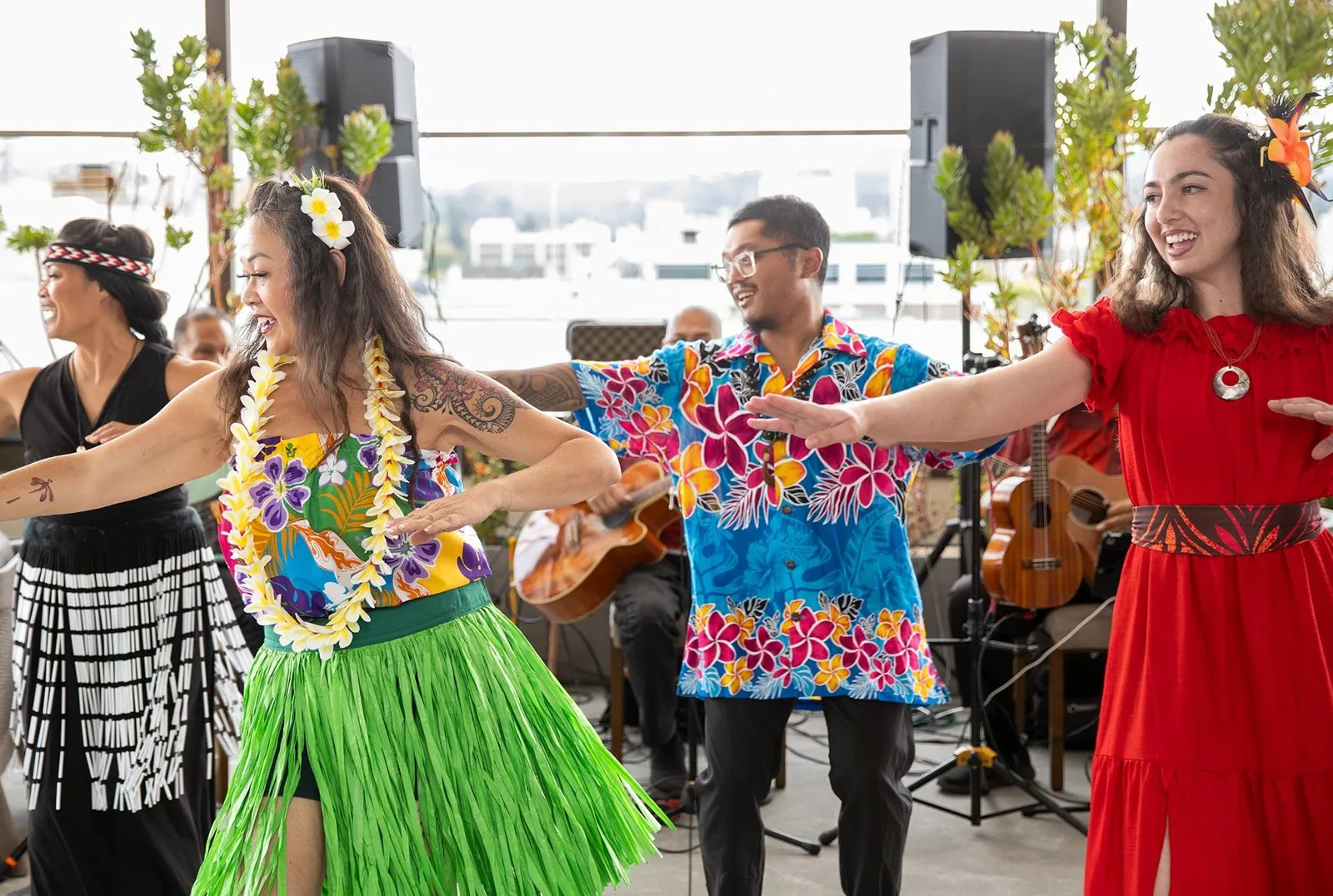 Musicians and dancers in island-style outfits performing at an outdoor event