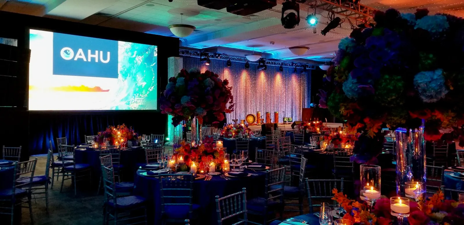 Evening reception with an "Oahu" screen, floral centerpieces and accent lighting