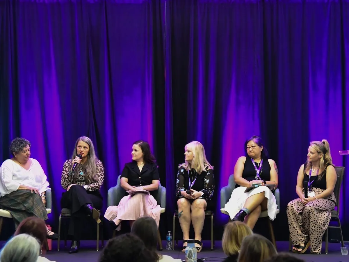 Panel discussion on a purple lit conference stage