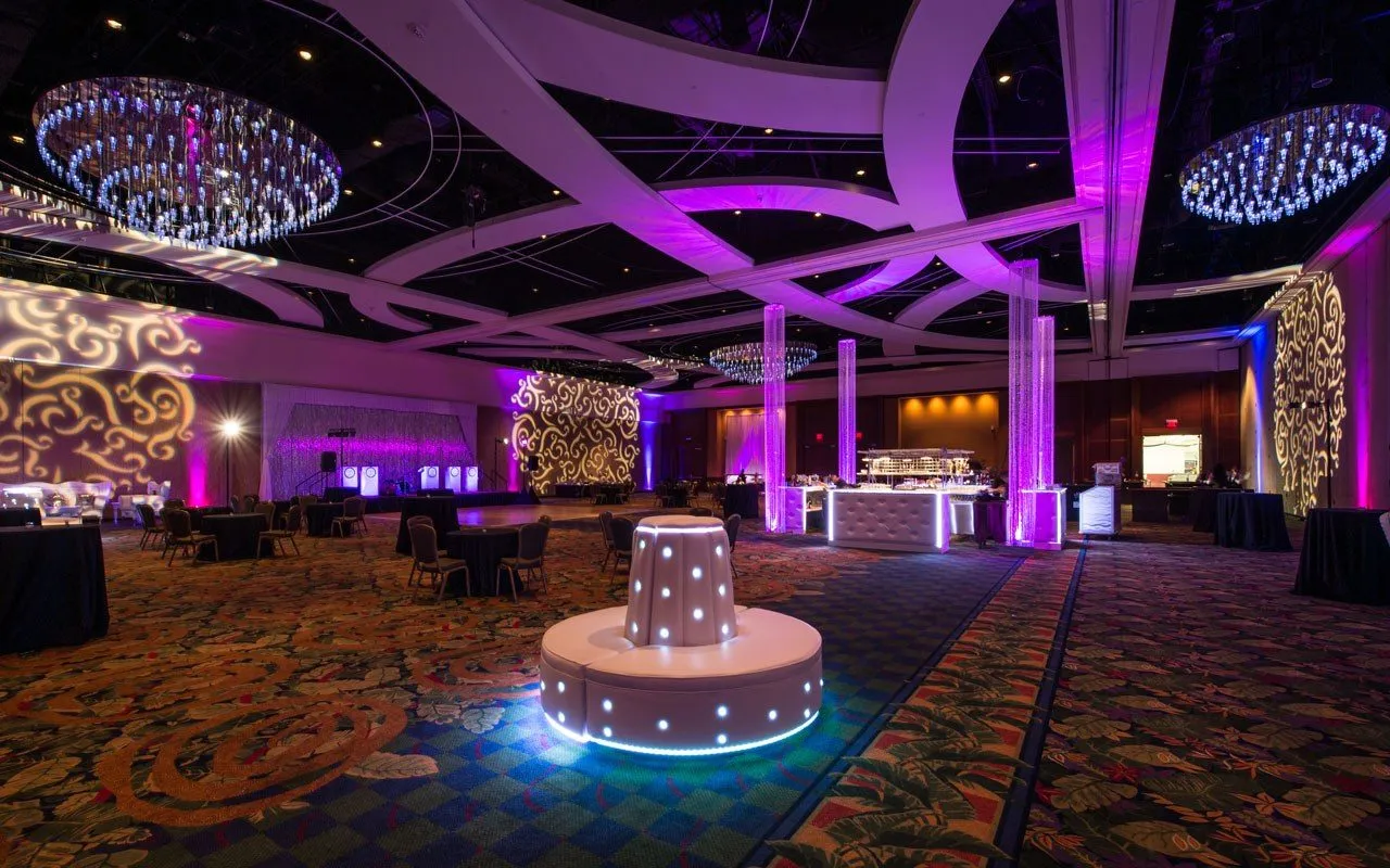 Ballroom reception with sculptural ceiling lighting and a lit center bar