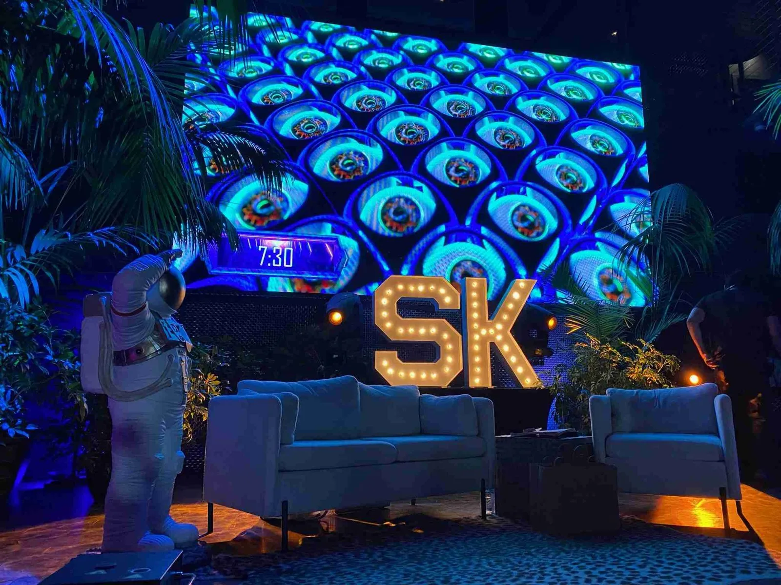 Lounge with sofas and illuminated SK letters in front of a patterned LED wall