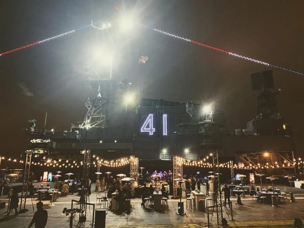 Evening event on a ship deck at night with a large lit number