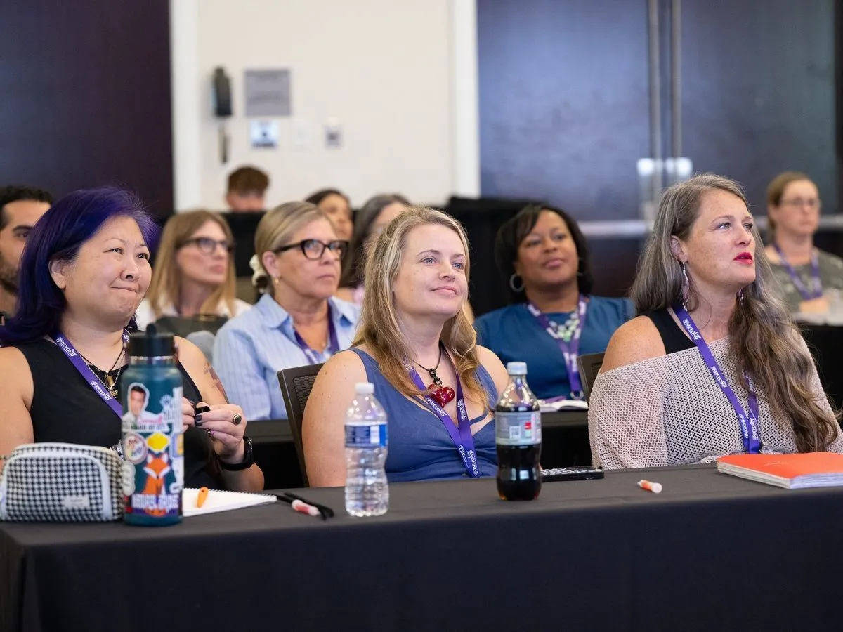 Attendees seated in a conference session listening to a speaker