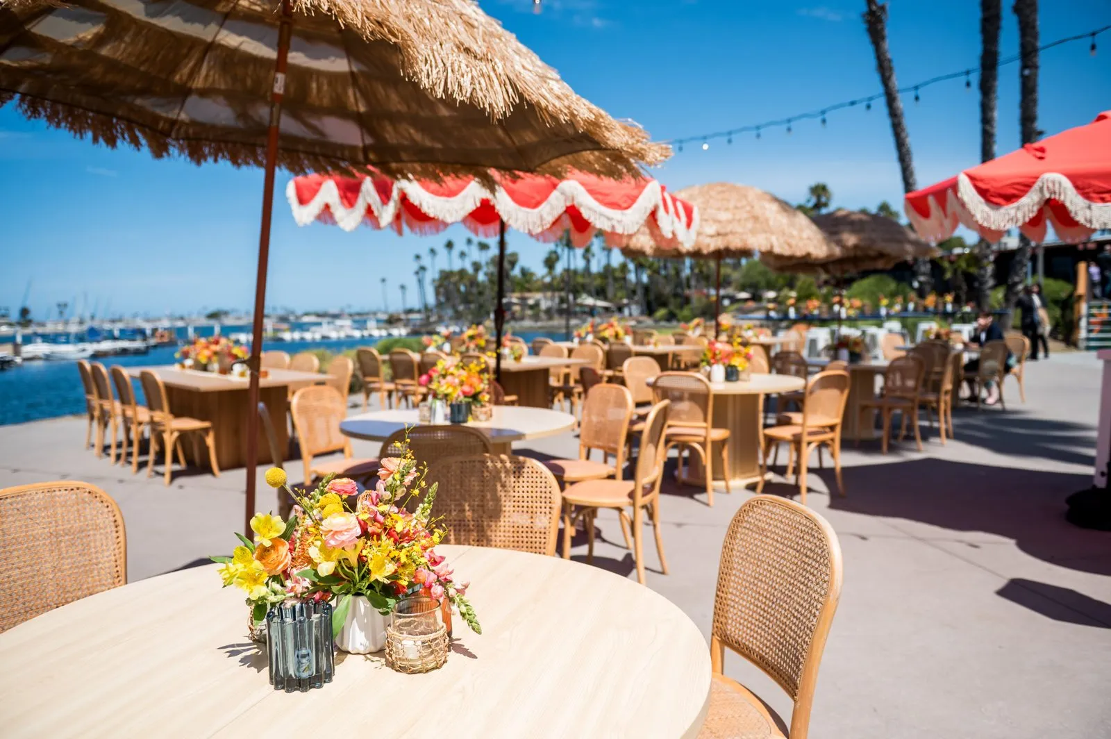 Waterfront patio with umbrella tables set for a group event