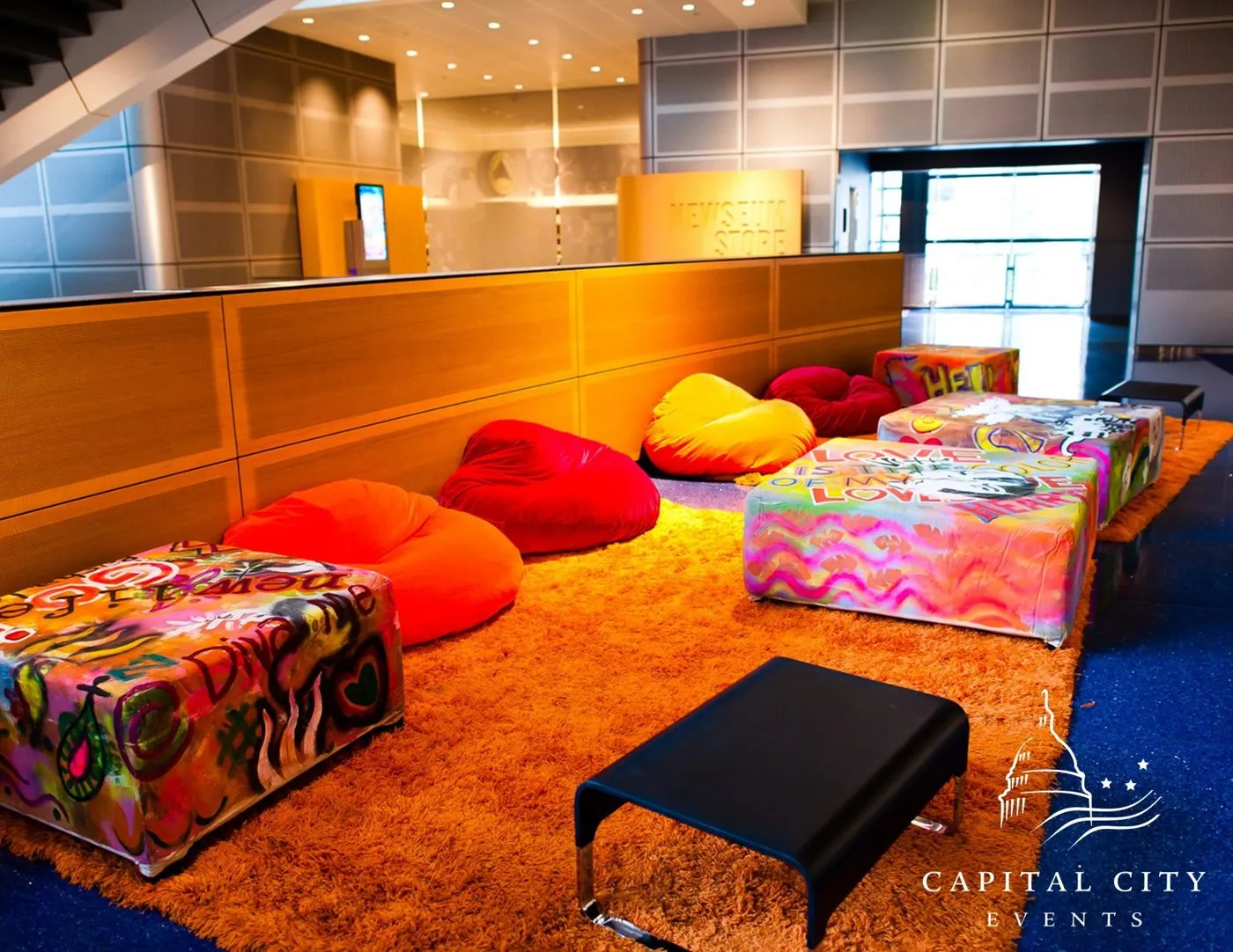 Lounge seating with colorful bean bags and low tables at a group reception