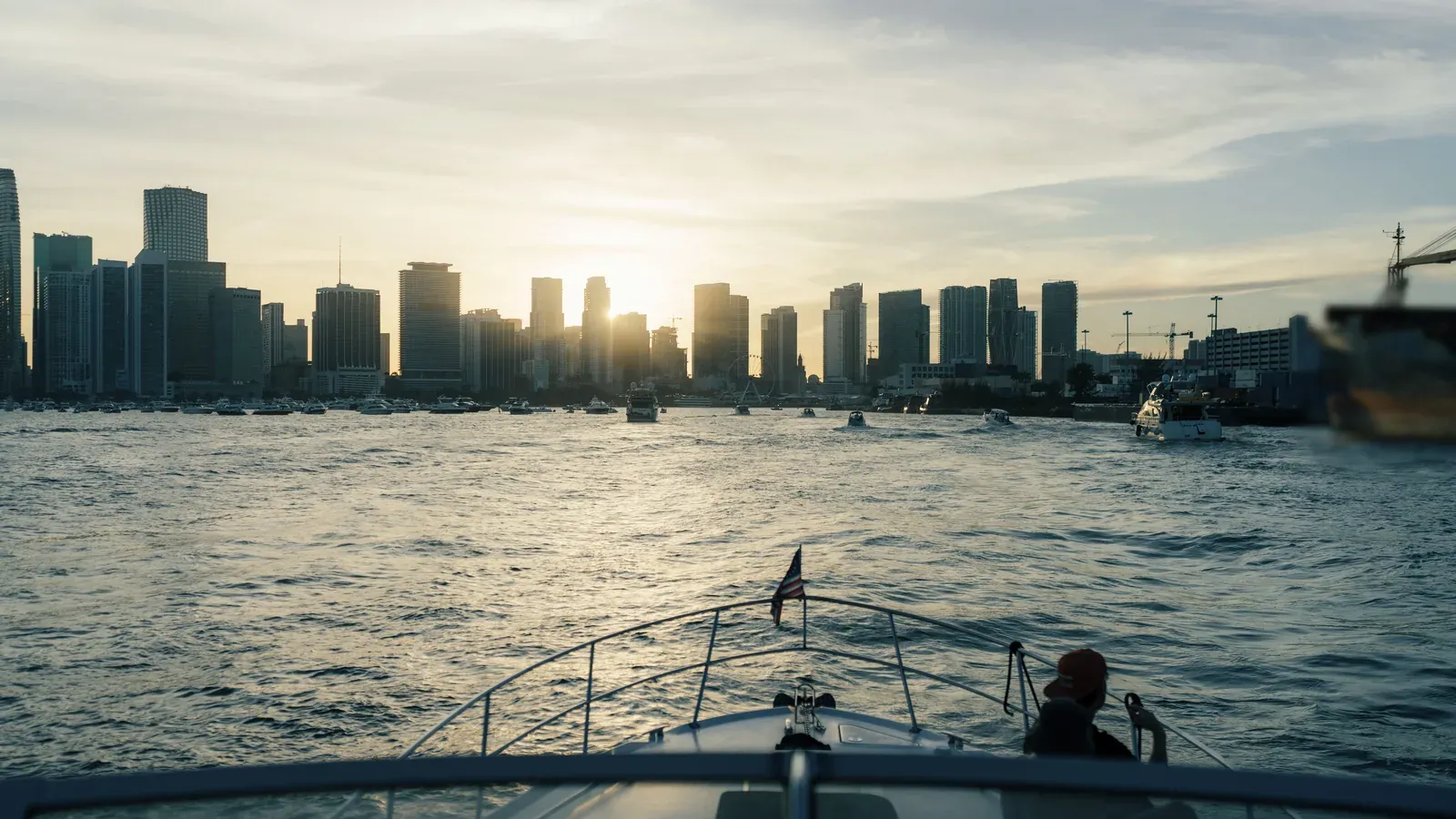 A boat heads across the water toward the city skyline at golden hour during an incentive trip in Miami.