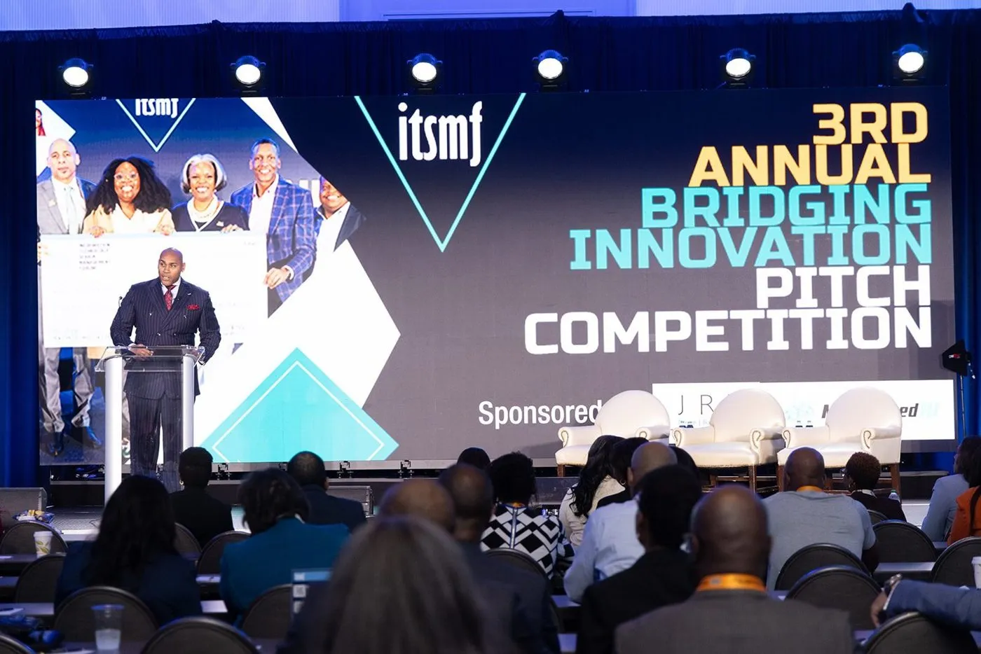 Pitch competition on a conference stage with an audience in the foreground