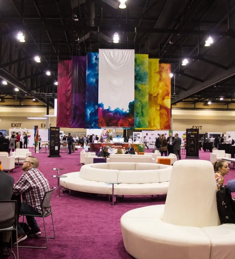 Colorful lounge seating and a bright display inside a large meeting hall