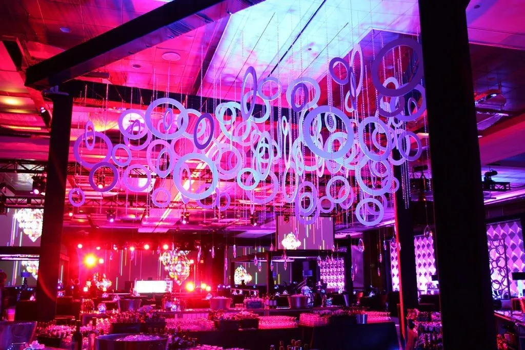 Venue lit in pink and purple with hanging ring installations for a final night event