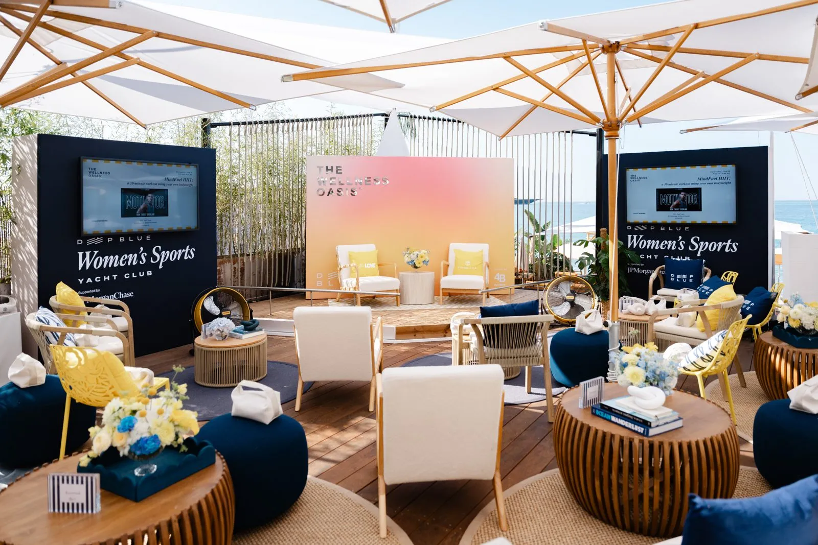 Lounge with sofas, screens and a branded backdrop set up for a conference activation