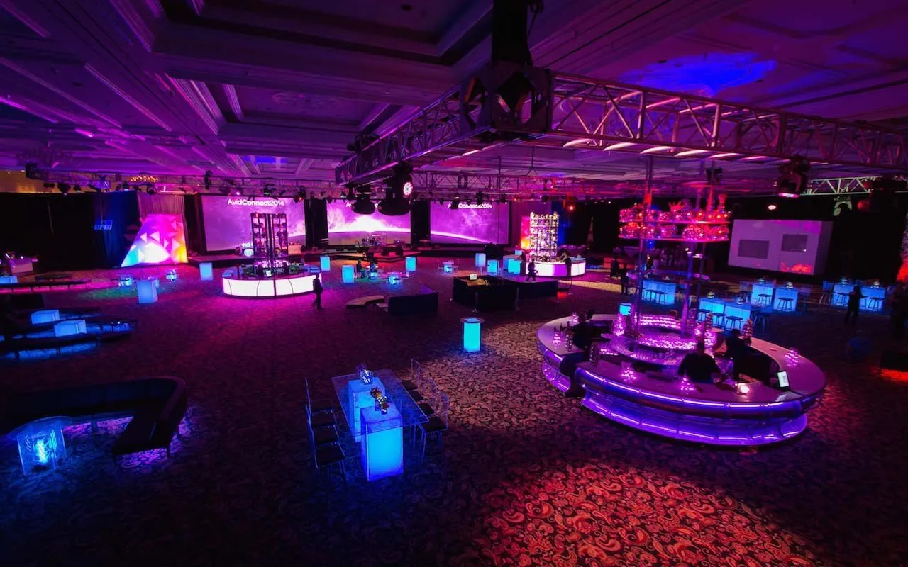 Ballroom lounge with illuminated seating pods and purple and pink lighting