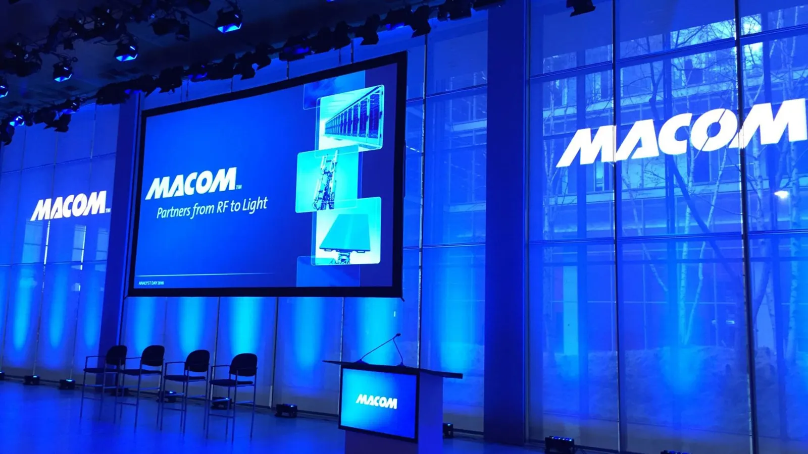 MACOM analyst day stage with blue lighting and screens
