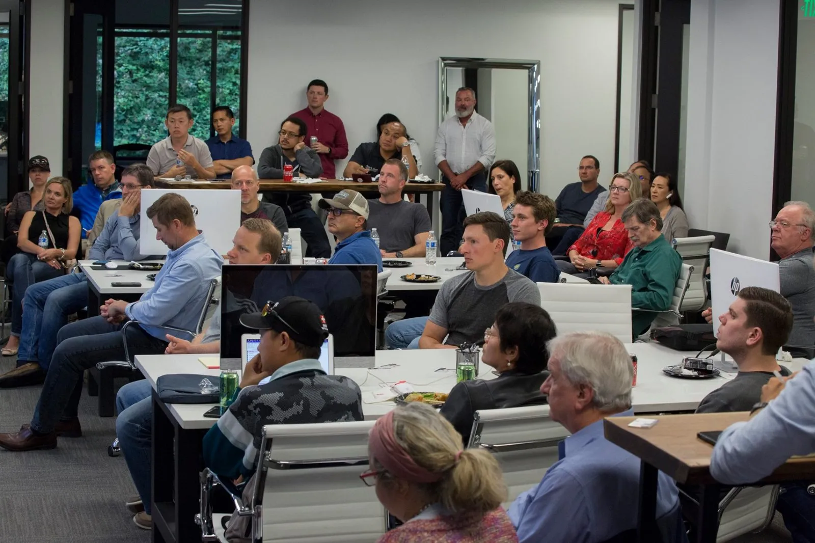 Attendees seated at tables during a Caliber company meeting