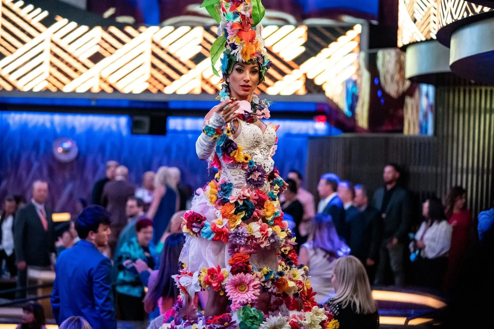 Performer in a tall floral headdress and costume at a reception