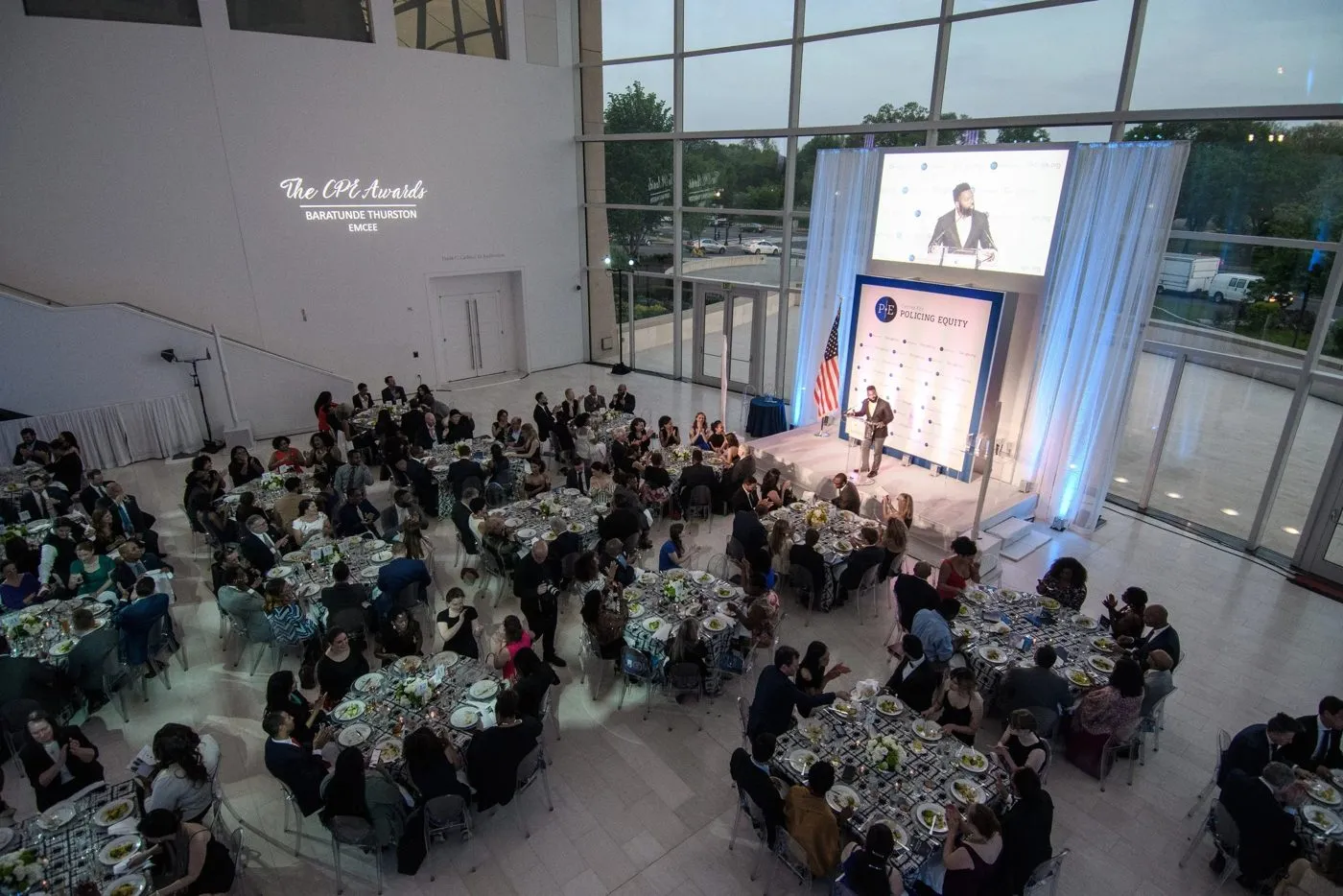 Overhead view of round dinner tables in a modern atrium for an awards dinner