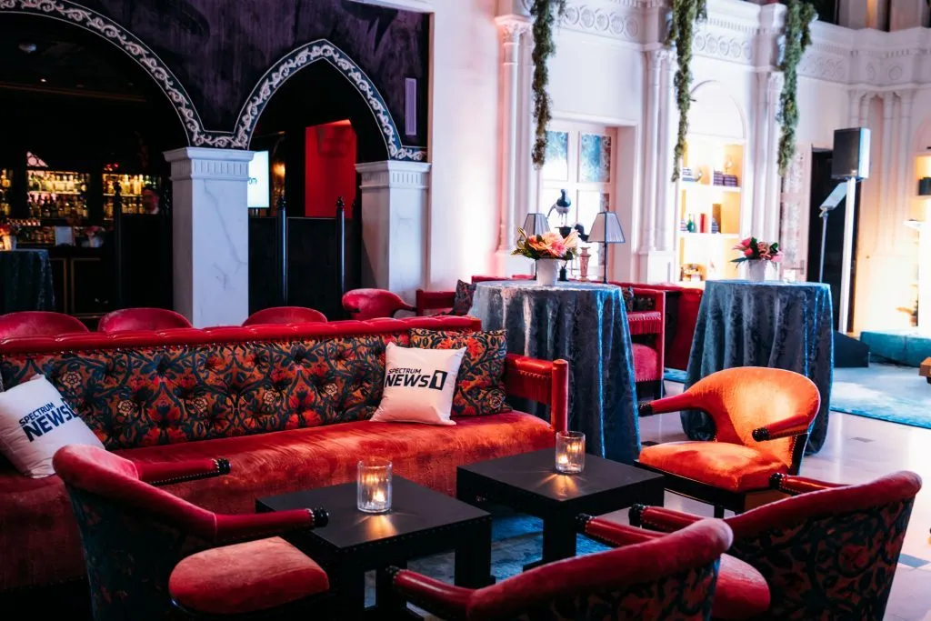 Lounge with red sofas and tables set up under arches