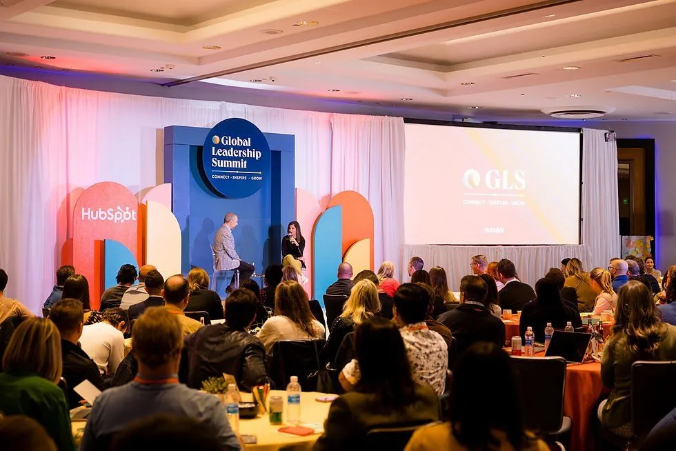 Leadership summit presentation in a ballroom with a branded screen