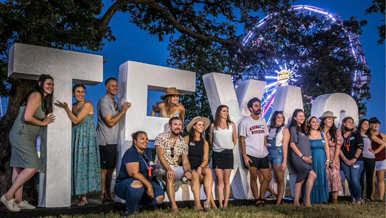 BCG staff posing in front of large TEXAS letters at the ranch day
