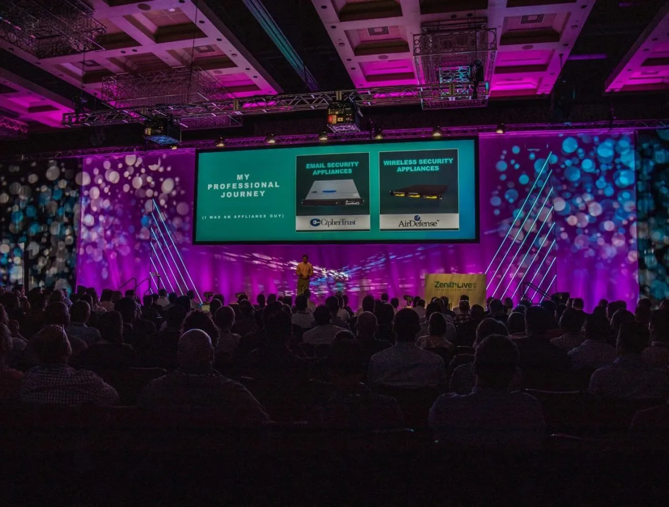 Conference general session with a floral-patterned stage backdrop