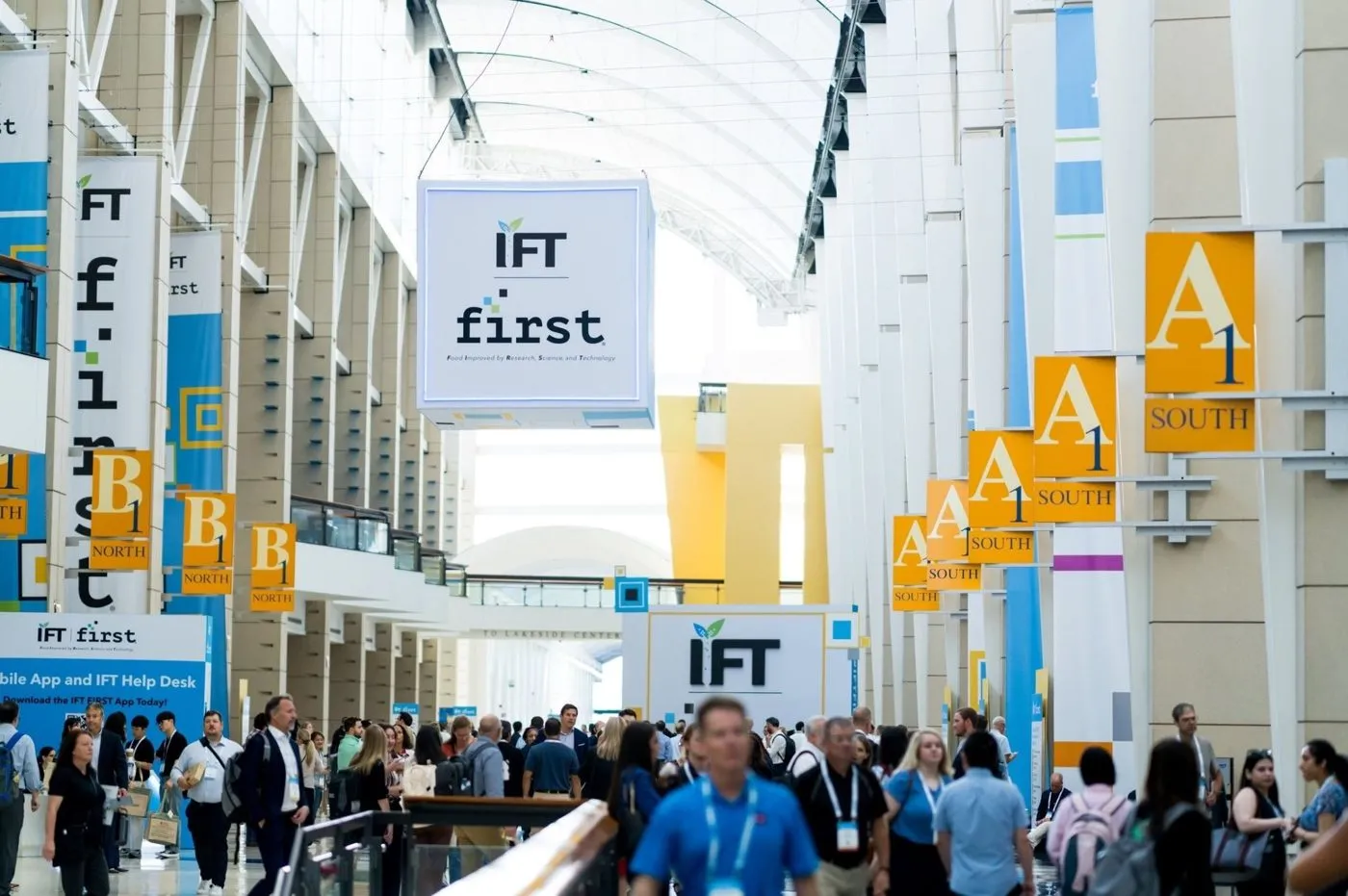 Attendees gathered in a convention hall atrium with hanging banners