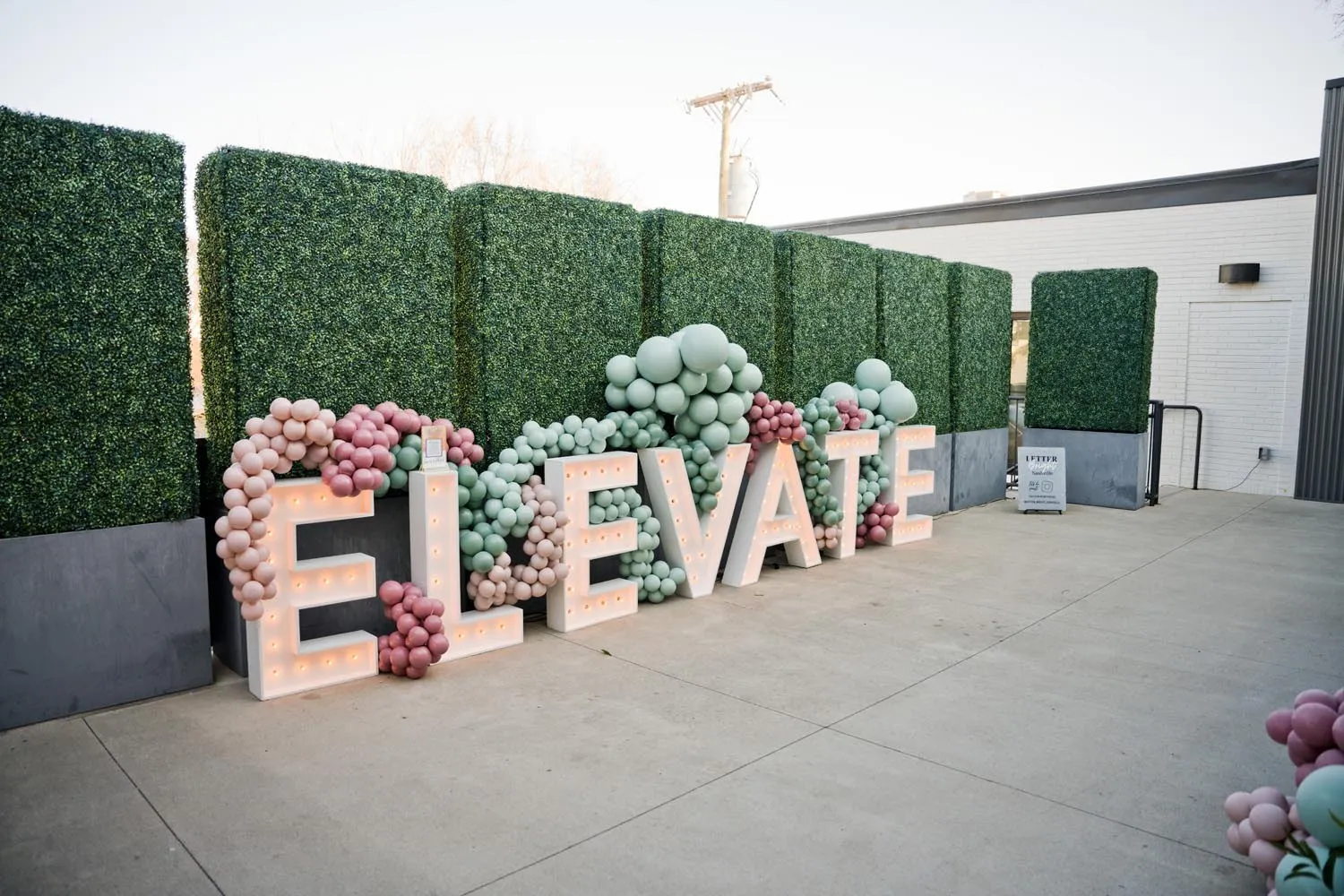 ELEVATE marquee letters with balloons on an outdoor terrace