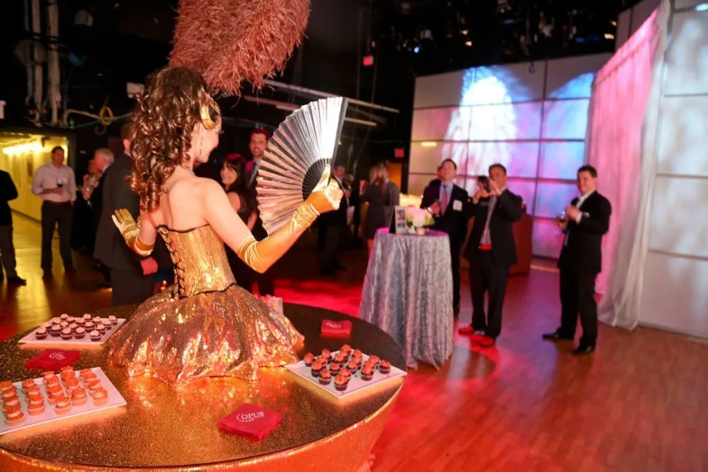 Performer in a feathered costume greeting guests at a corporate reception