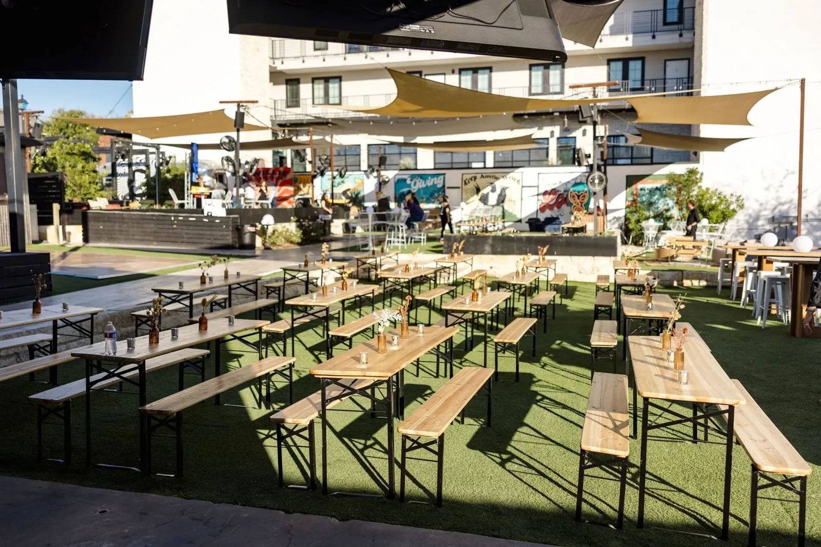 Picnic tables under shade sails at Inn Cahoots, set for an offsite night during a leadership conference