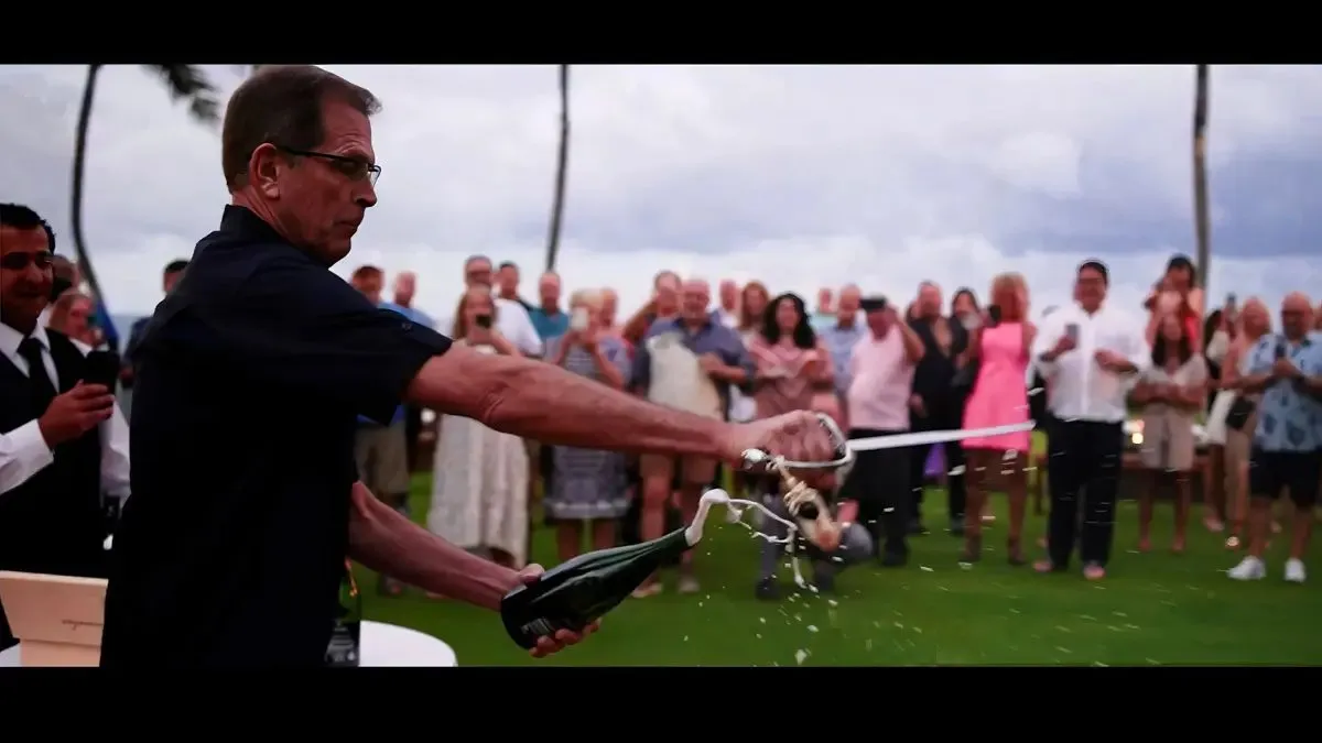 Guest opening a bottle during an outdoor celebration