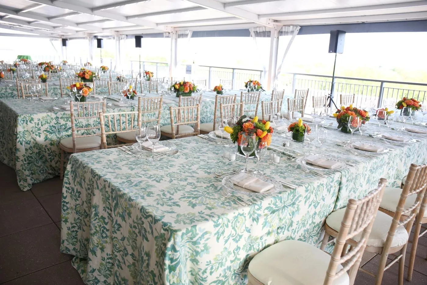 Long banquet table with floral runners in a glass walled event space