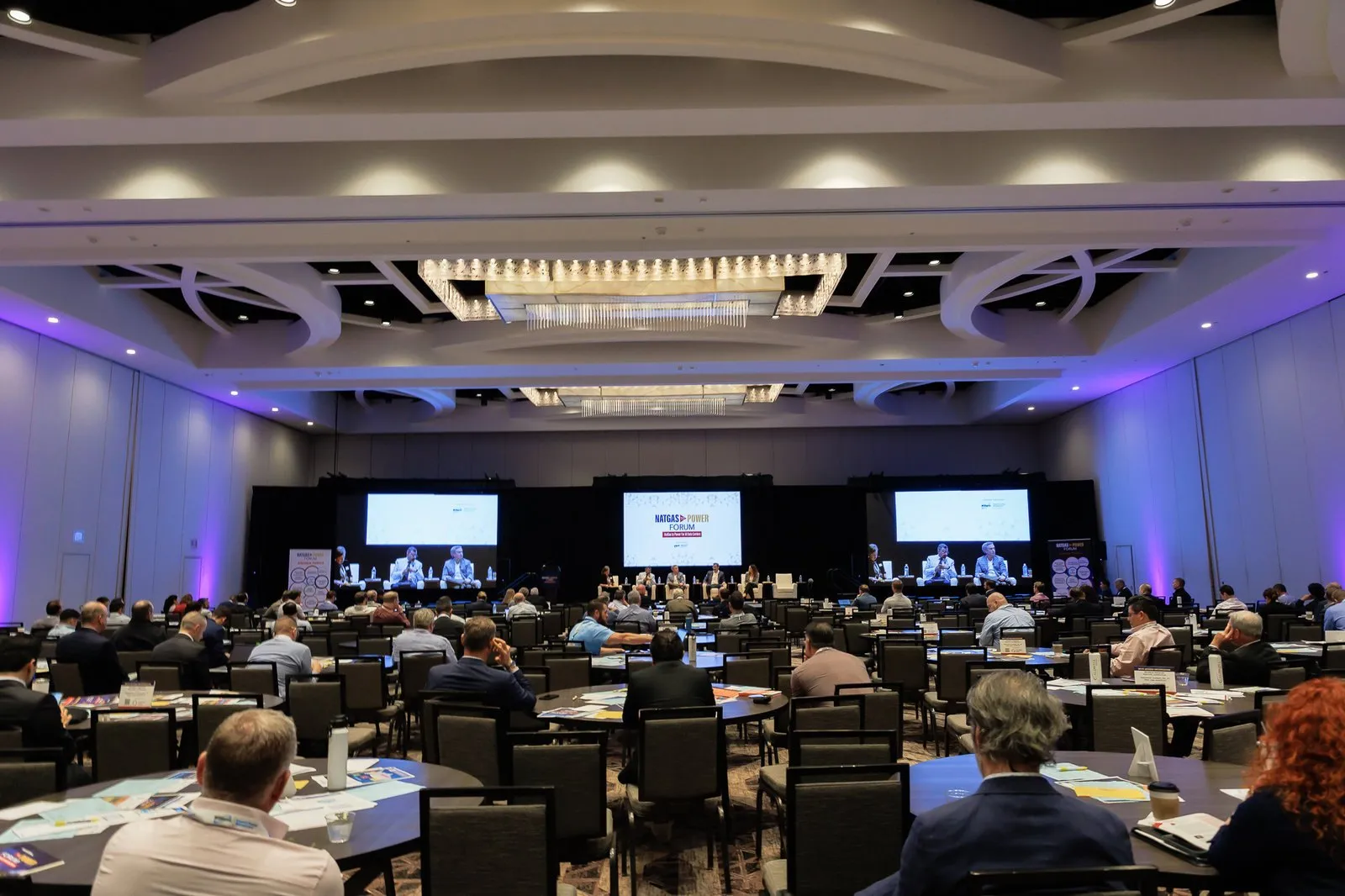 Conference room with screens and stage lighting at the NatGas to Power Conference