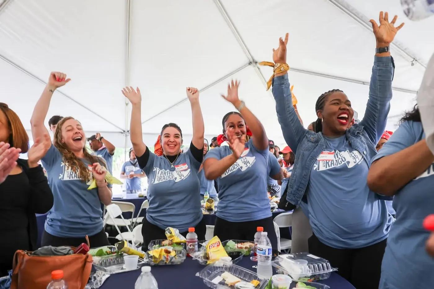 Employees cheering in a tent at a company event