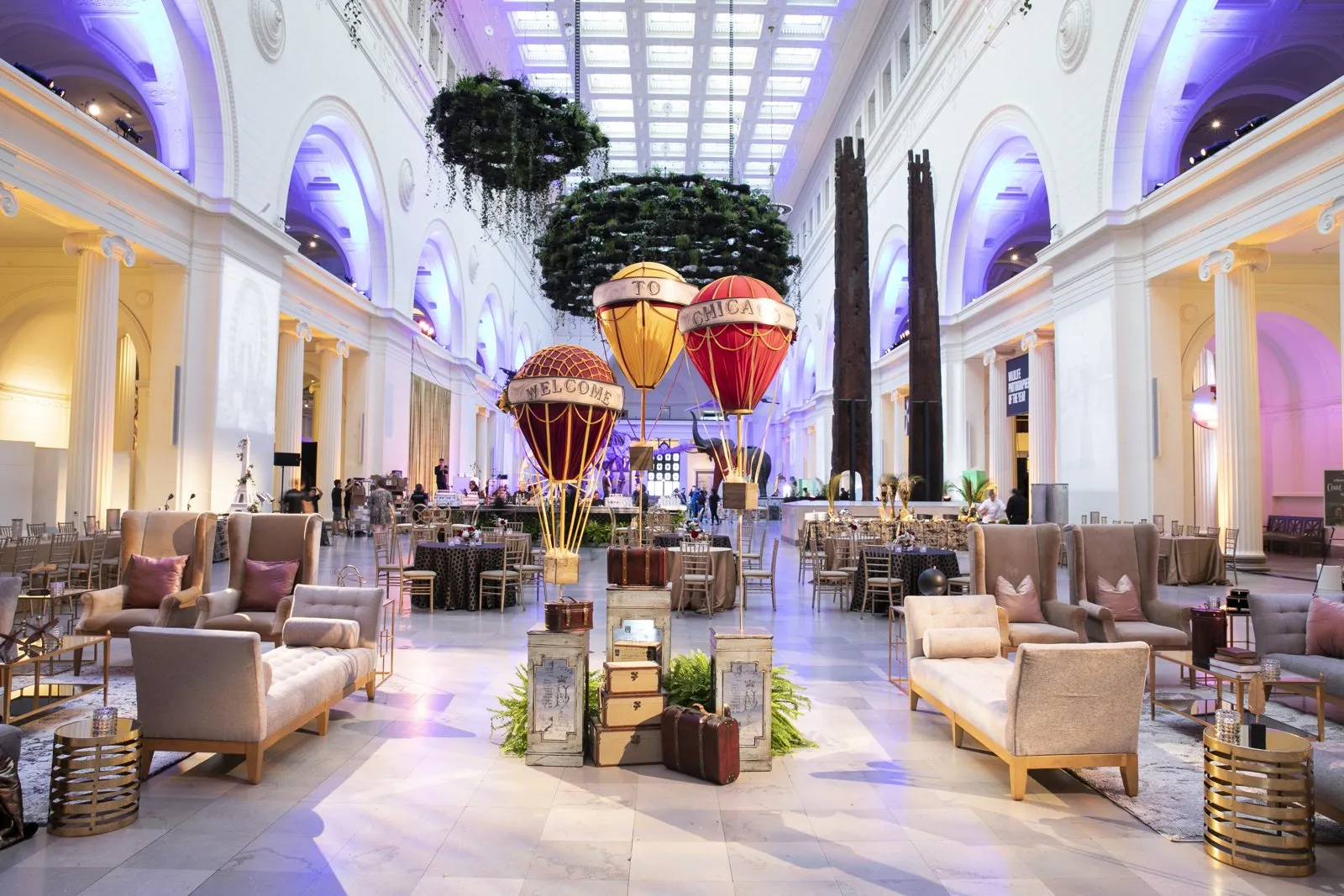 Lounge furniture and hanging decor in a grand columned hall