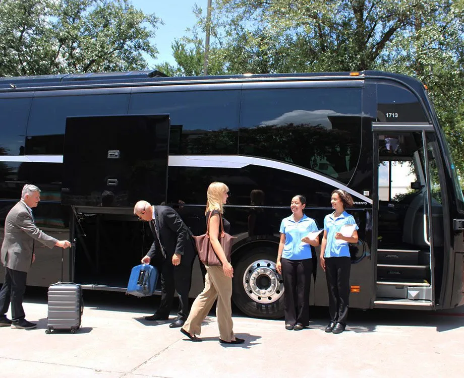 Guests boarding a motorcoach with event staff in matching shirts