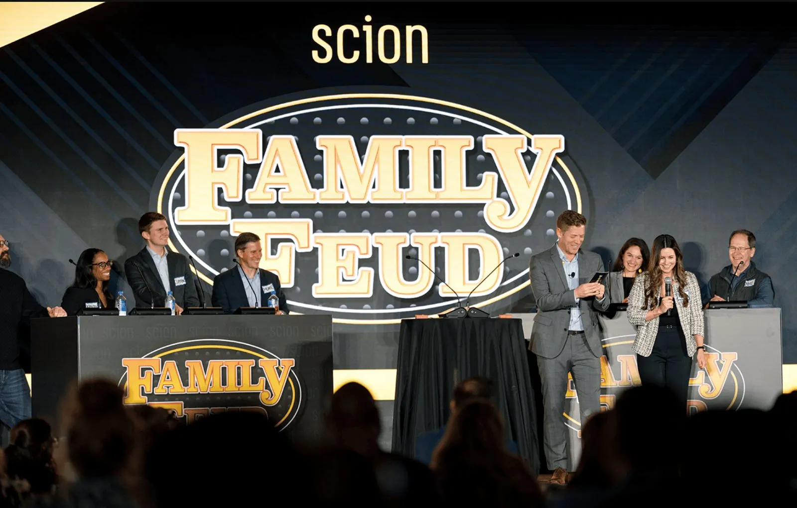 Employees on stage at a game show style team event