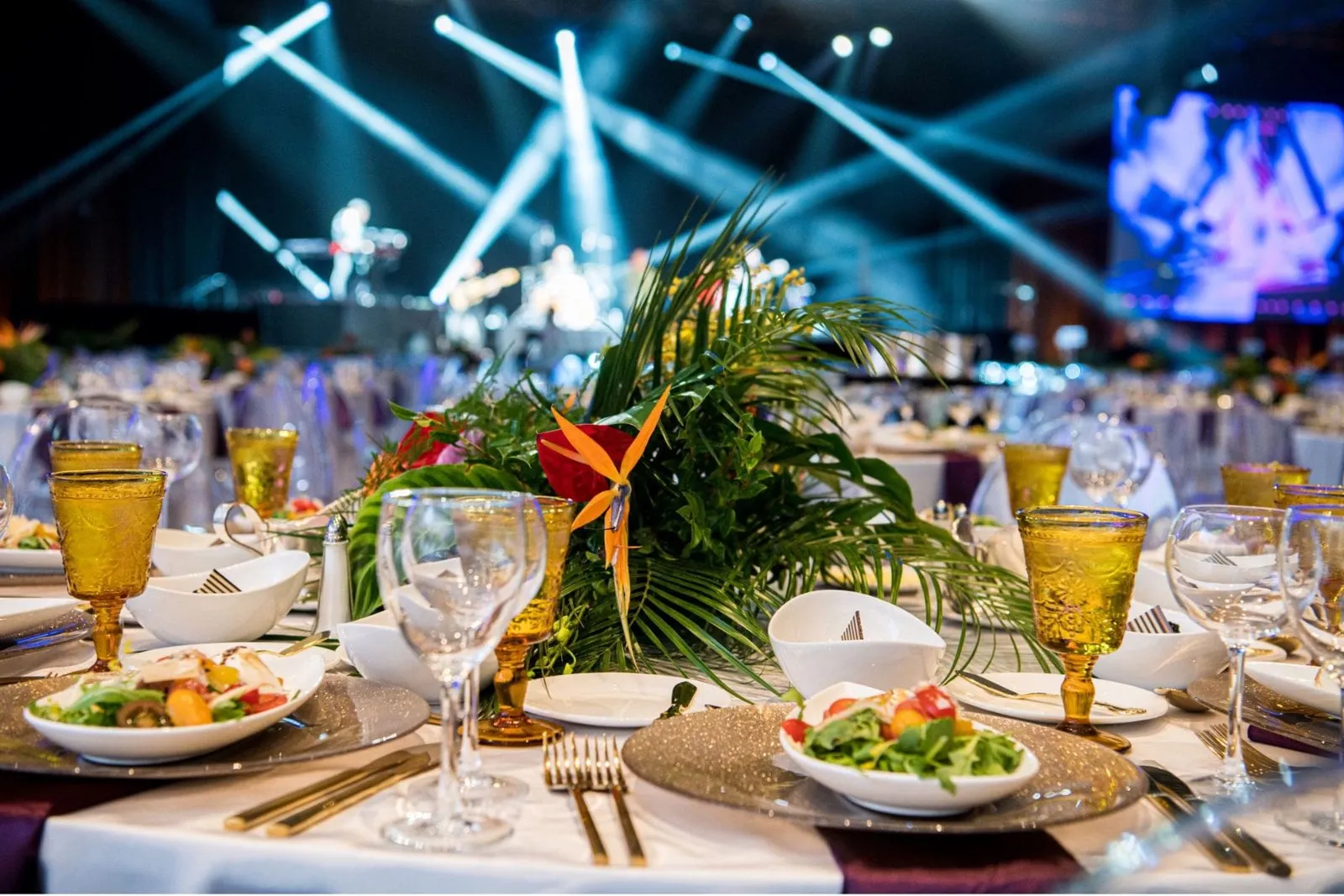 Dinner table with a tropical centerpiece under stage lighting at the A&E AMA Dinner