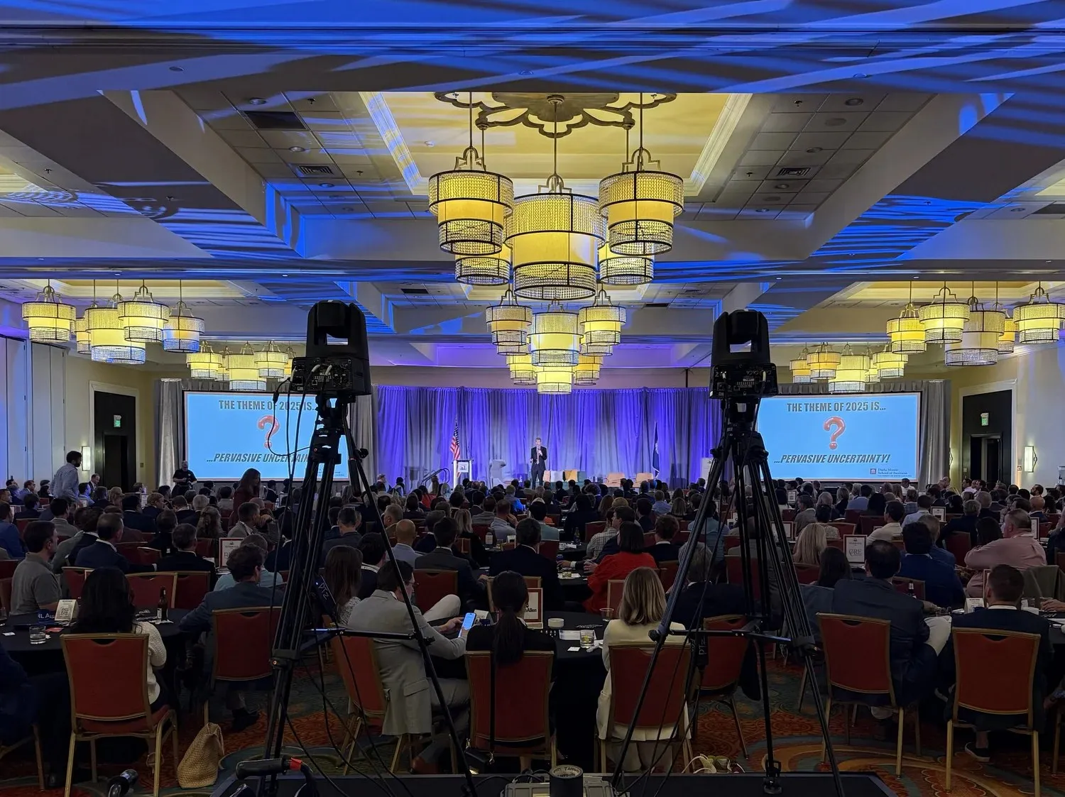 Large ballroom general session with stage screens and camera riser
