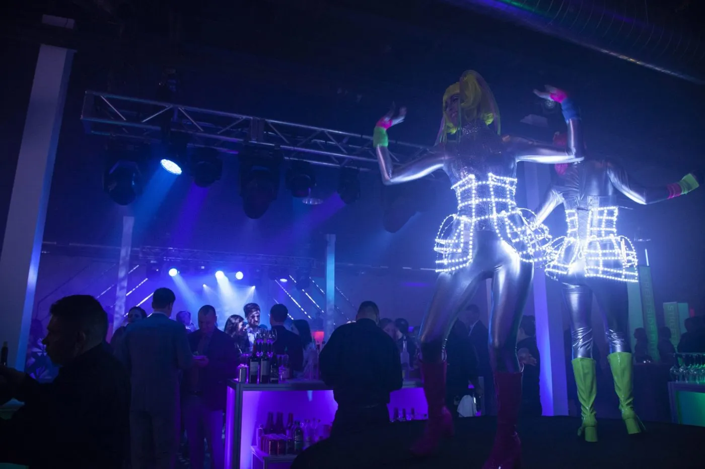 Performer in a light up costume on stage in front of a crowd at a corporate celebration