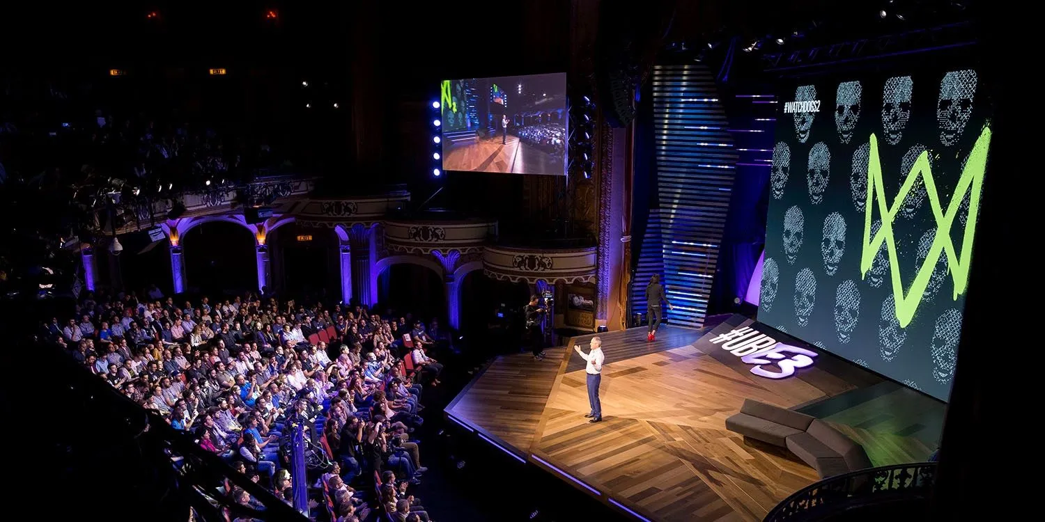 Conference stage with a lit presentation set and audience seating