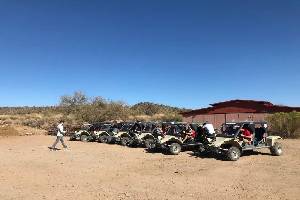 Row of off-road vehicles lined up for a group desert excursion