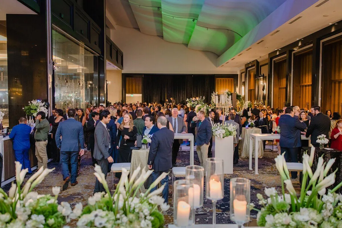 Reception crowd in a modern building atrium with candle lit tables