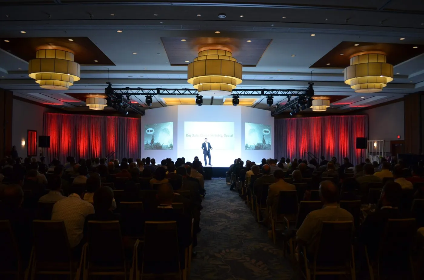 Ballroom set with a lit stage and screens for a company program
