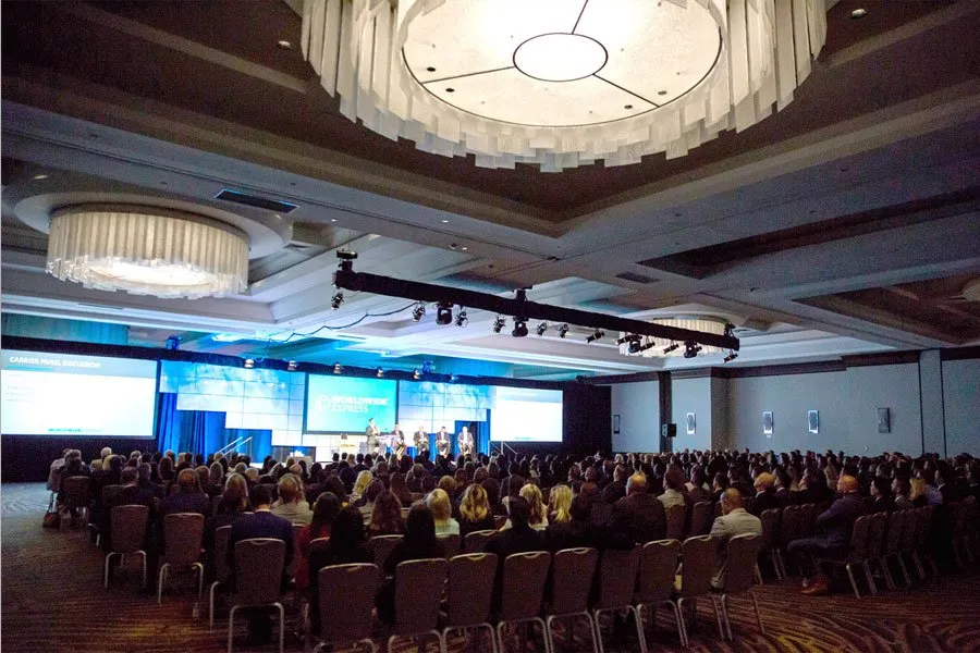 Attendees seated in a hotel ballroom for a corporate conference general session